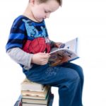 schoolboy is sitting on books | Toddlebabes - Learn to Play - Play to Learn